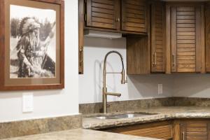 una cucina con lavandino e una foto appesa al muro di PARK STATION 229 condo a Park City