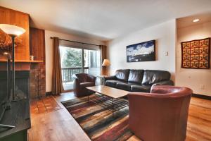 un soggiorno con un divano in pelle e un tavolo di SNOW FLOWER 104 condo a Park City