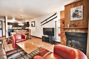 un soggiorno con camino e sedie rosse di SNOW FLOWER 104 condo a Park City