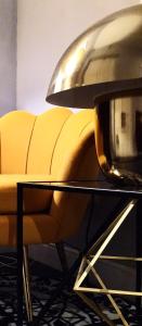 een gele bank en een tafel met een lamp bij NIK Rooms in Rome