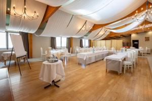 une salle de banquet avec des tables blanches et des chaises blanches dans l'établissement Best Western Le Relais de Laguiole Hôtel & Spa, à Laguiole