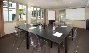 a conference room with a table and chairs and a screen at Best Western Plus Hotel Kregenn in Quimper