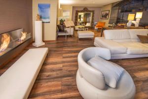 a living room with white furniture and a fireplace at Best Western Plus Hotel Kregenn in Quimper