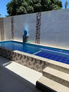 a swimming pool with a fountain in a building at Sol e Praia in Prado