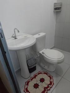 a bathroom with a toilet and a sink at Hostel Lize in Cumbica +81 photos