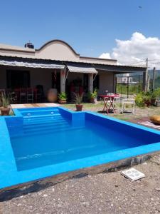 a blue swimming pool in front of a house at La Soñadita in Salta