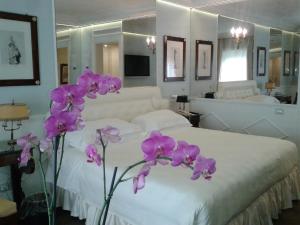 a bedroom with a white bed with purple flowers at Excelsior Palace Portofino Coast in Rapallo