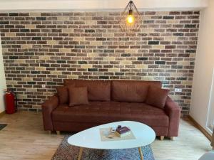 un soggiorno con divano marrone e parete in mattoni di The Pearl a Sarajevo