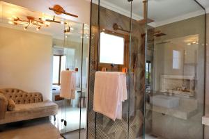 uma casa de banho com um chuveiro e uma porta de vidro em Parador São João em Canela