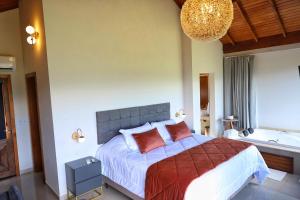 a bedroom with a large bed and a bath tub at Parador São João in Canela