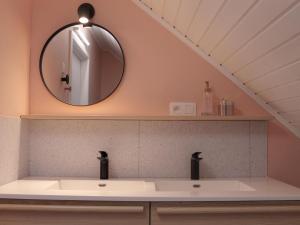 ein Bad mit einem Waschbecken und einem Spiegel in der Unterkunft Attractive bungalow in Lanaken with fenced garden in Lanaken
