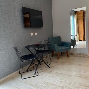 un soggiorno con tavolo, sedie e TV di Pousada Alpes Azul a Campos do Jordão