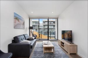 a living room with a couch and a tv at Sandy Hill apartment, Sandringham in Sandringham