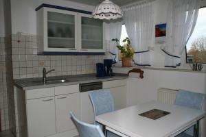 eine Küche mit einer Spüle sowie einem Tisch und Stühlen in der Unterkunft Ferienwohnung Angela in Neuenkirchen