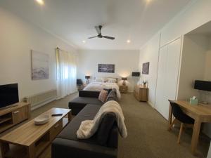 Myee Alpine Retreat في جبل بيوتي: غرفة معيشة كبيرة مع سرير وأريكة