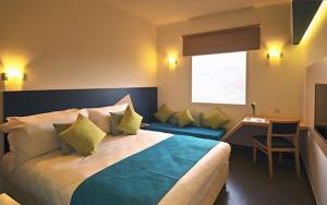 a hotel room with a large bed and a desk at Relax Hôtel Oujda in Oujda +17 photos
