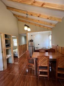 cocina y comedor con mesa de madera y sillas en Cabaña Las Patagüas - Coñaripe, en Coñaripe