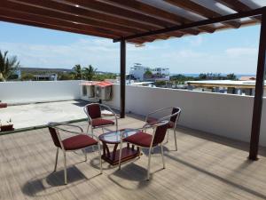 un patio avec des chaises et une table sur le toit dans l'établissement Ocean Dreams Galapagos, à Puerto Ayora