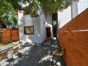 a house with a wooden fence and a table and chairs at cabaña los robles in Licán Ray