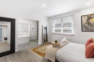 a bedroom with a king sized bed and a bathroom at Longley Place in Alfredton