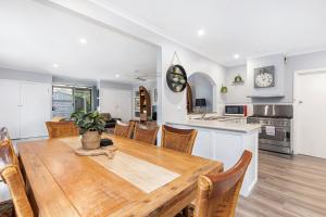 a kitchen and dining room with a wooden table and chairs at Longley Place in Alfredton
