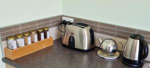 a kitchen counter with a toaster and a tea kettle at Hyecroft Lodge in Whangarei