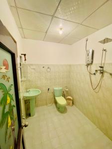 La salle de bains est pourvue de toilettes vertes et d'un lavabo. dans l'établissement Sheran Safari House, à Uda Walawe