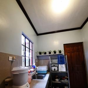 uma cozinha com um balcão com um lavatório e uma janela em Angel's Place Transient House em Tagbilaran