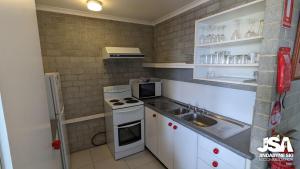 a small kitchen with a sink and a stove at Tanderra 4 in Jindabyne