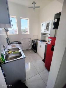 eine Küche mit einer Spüle und einem roten Kühlschrank in der Unterkunft La mejor ubicación de Arica in Arica