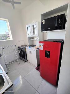アリカにあるLa mejor ubicación de Aricaのキッチン(赤い冷蔵庫、電子レンジ付)