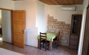 a table and chairs in a room with a stone wall at Apartments by the sea Valun, Cres - 386 in Valun