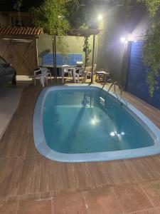 duży basen w ogrodzie w nocy w obiekcie Casa grande e bela w mieście Porto Seguro