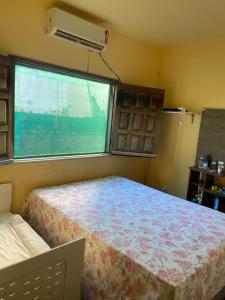 niewielka sypialnia z łóżkiem i oknem w obiekcie Casa grande e bela w mieście Porto Seguro