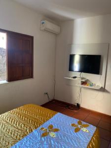 a bedroom with a bed and a flat screen tv at Casa grande e bela in Porto Seguro