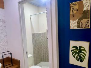 uma casa de banho com uma parede azul e um chuveiro em Mar Rio casa de praia em Piçarras