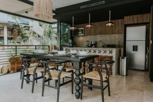 a dining room with a table and chairs in a kitchen at Cenote + Swim-Up + Luxury Condo in Tulum