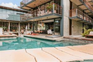 a house with a swimming pool in front of a building at Cenote + Swim-Up + Luxury Condo in Tulum