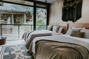 a bedroom with two beds and a large window at Cenote + Swim-Up + Luxury Condo in Tulum +43 photos