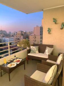 balcón con sofás y mesas y vistas a la ciudad en Apartamento Boulevard Poniente, en Viña del Mar
