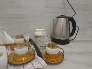 a tea kettle and cups on a table at Gloria Inn in Negombo