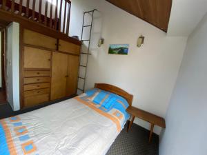 1 dormitorio con 1 cama y armario de madera en La Viña - Sogamoso, en Sogamoso