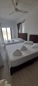 a group of three beds in a room at ONE HOTEL in Girardot