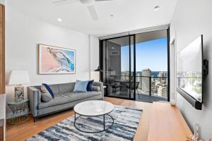 a living room with a couch and a table at Broadbeach Casino Private Apartments - GCLR in Gold Coast