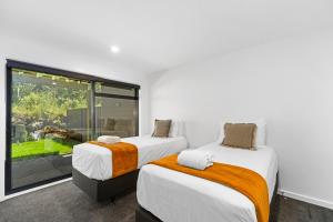 two beds in a room with a window at Blue Dun Views - Taupo in Taupo