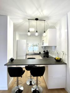 a kitchen with white cabinets and a large island with bar stools at BuenaVista Gigantes Marina in Acantilado de los Gigantes