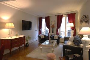 パリにあるTwo-Bedroom Apartment Champs-Elyséesのリビングルーム(ソファ、テーブル付)
