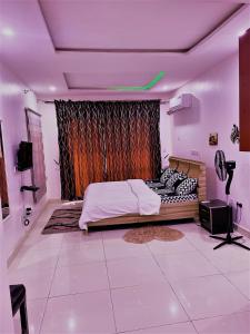 a bedroom with a bed in a room with purple lighting at Entire Serviced Two bedroom duplex Abuja - 24hr WIFI, POWER, OFFICE, FULL KITCHEN in Abuja