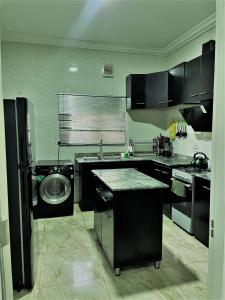 a kitchen with a sink and a washing machine at Entire Serviced Two bedroom duplex Abuja - 24hr WIFI, POWER, OFFICE, FULL KITCHEN in Abuja