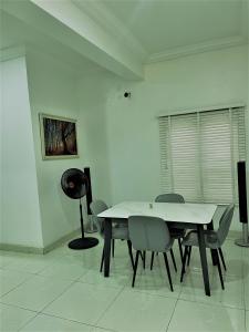 a white dining room with a table and chairs at Entire Serviced Two bedroom duplex Abuja - 24hr WIFI, POWER, OFFICE, FULL KITCHEN in Abuja